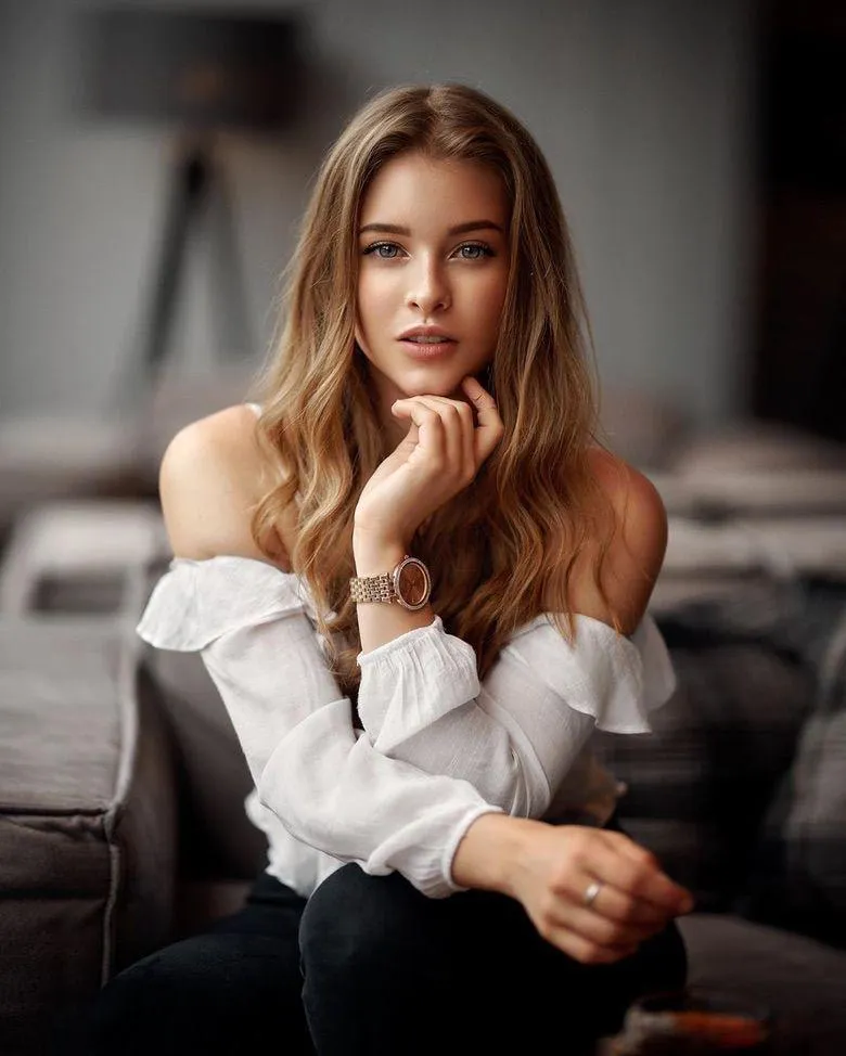 Elegant Woman in Off Shoulder Top Sitting on Cozy Couch