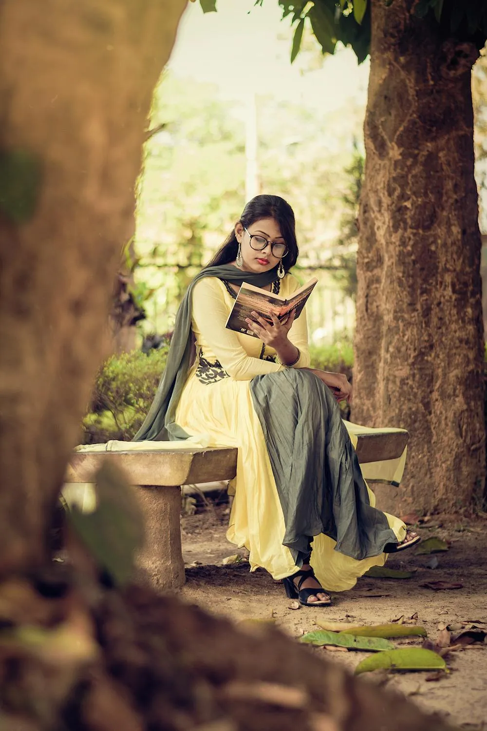 Elegant Woman Reading a Book Outdoors by a Rustic Stone Wall