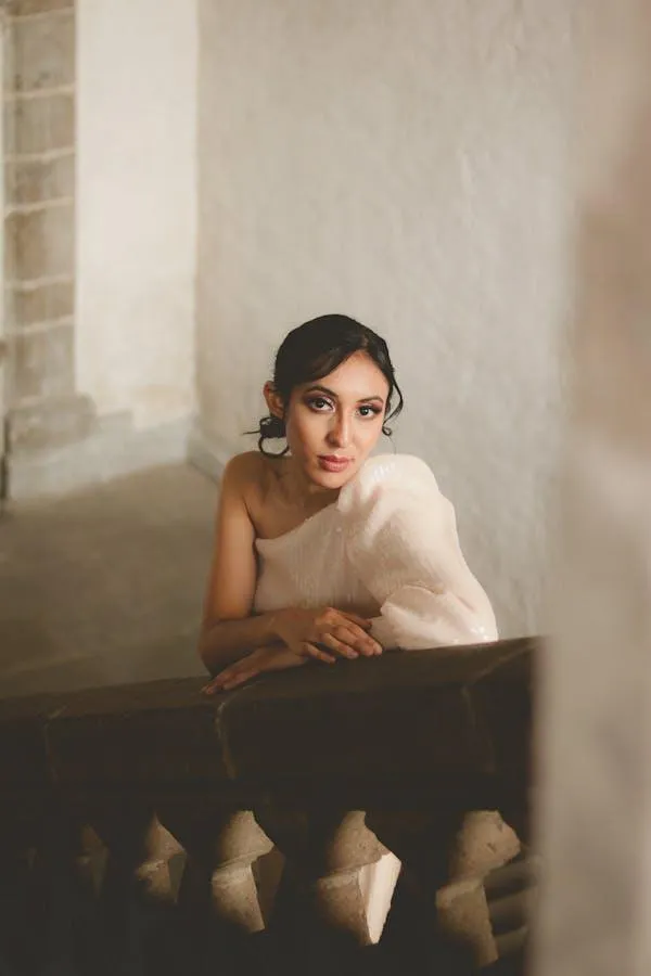 Elegant Woman in a Soft Dress Leaning on a Stone Staircase