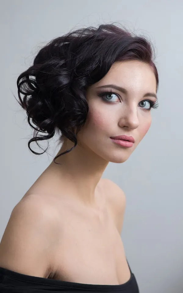 Elegant Woman with Styled Hair in a Simple Light Background