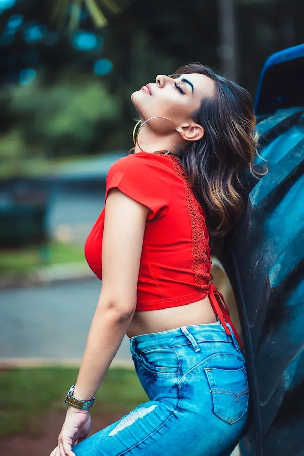 Energetic Woman Flipping Hair Back Outdoors in Red Crop Top