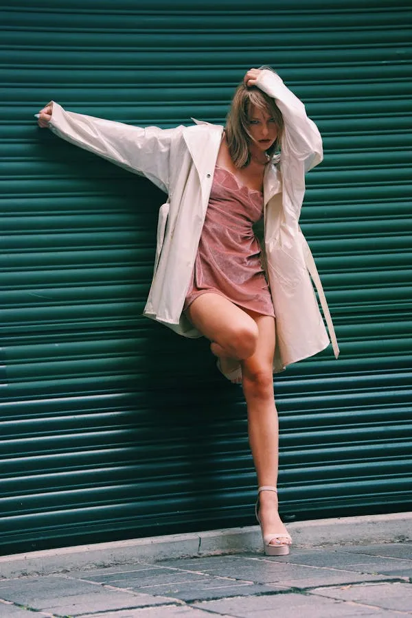 Energetic Woman Lying in a Pink Dress by Metal Shutters