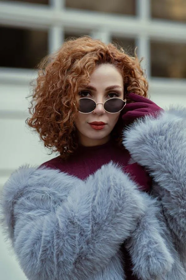 Fashionable Woman in a Fur Coat and Glasses Walking Outside