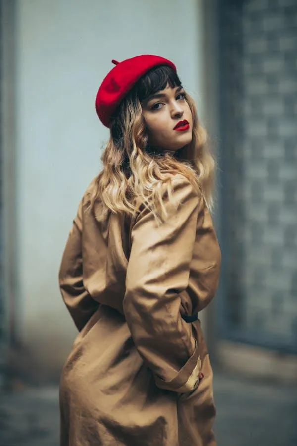 Fashionable Woman in a Tan Trench Coat and Red Beret Posing