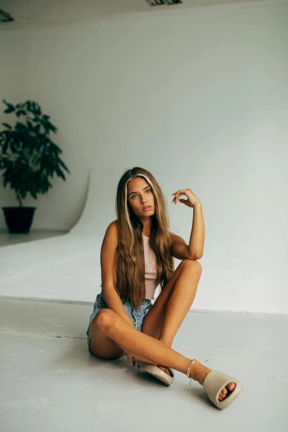 Female Model in a Brown Outfit Posing Near Indoor Greenery