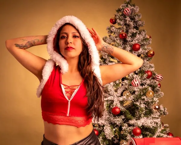 Festive Model in Santa Outfit Standing by the Christmas Tree