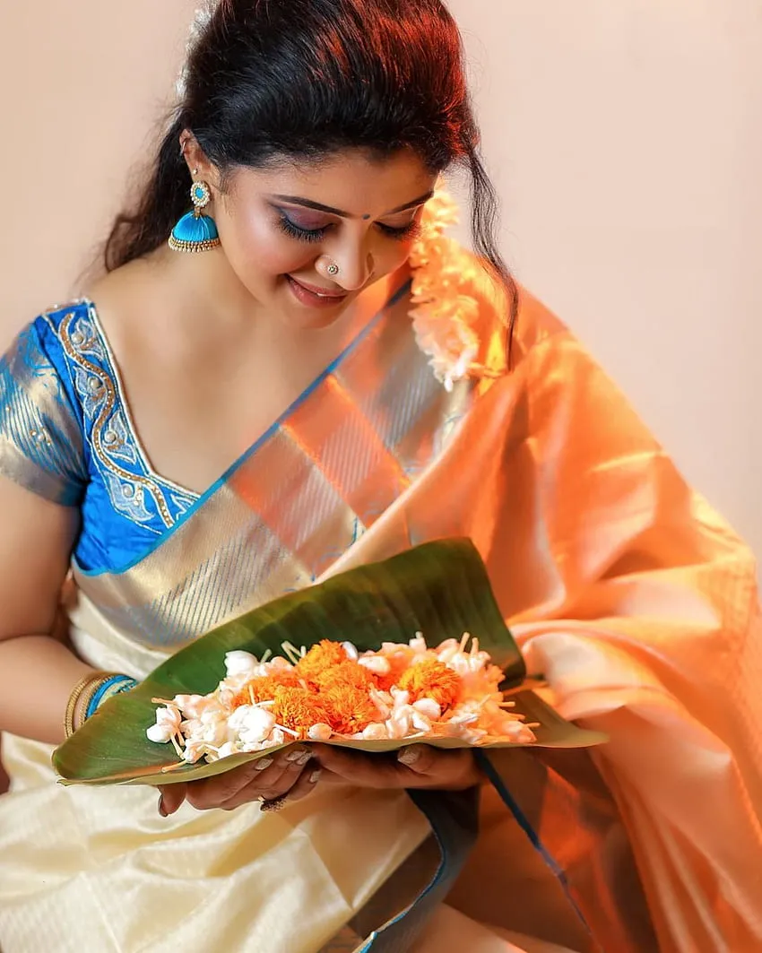 Gayathri Shan in a saree holding colourful flowers wallpaper