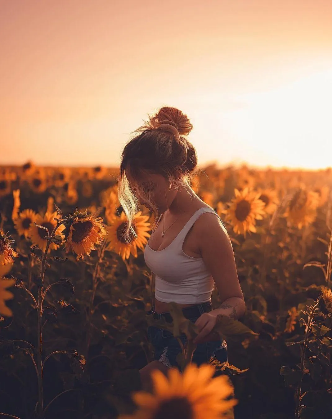 Girl in a Field At Sunset with Flowers and Warm Light Image