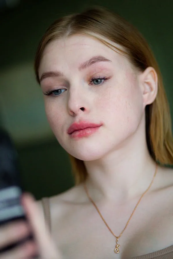 Girl Looking At Phone Screen with Neutral Soft Expression