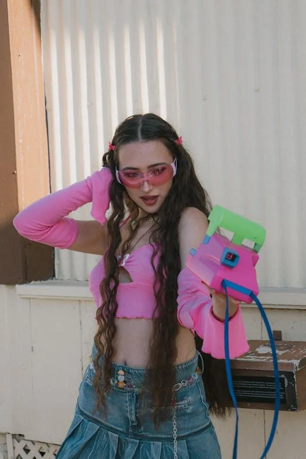 Girl in Pink Jacket and Jeans Posing with Playful Sunglasses