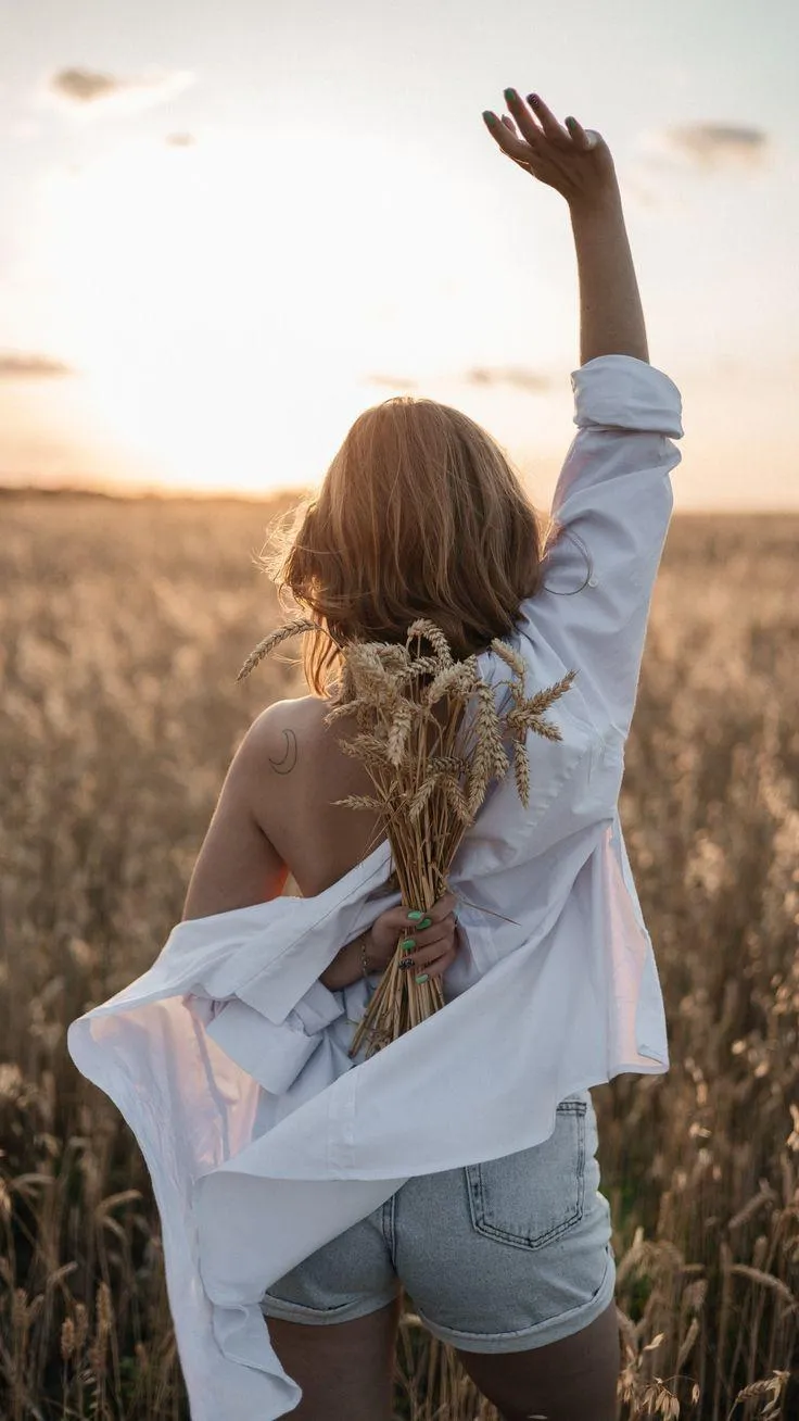 Girl Raising Her Hand While Standing in Tall Grass Wallpaper