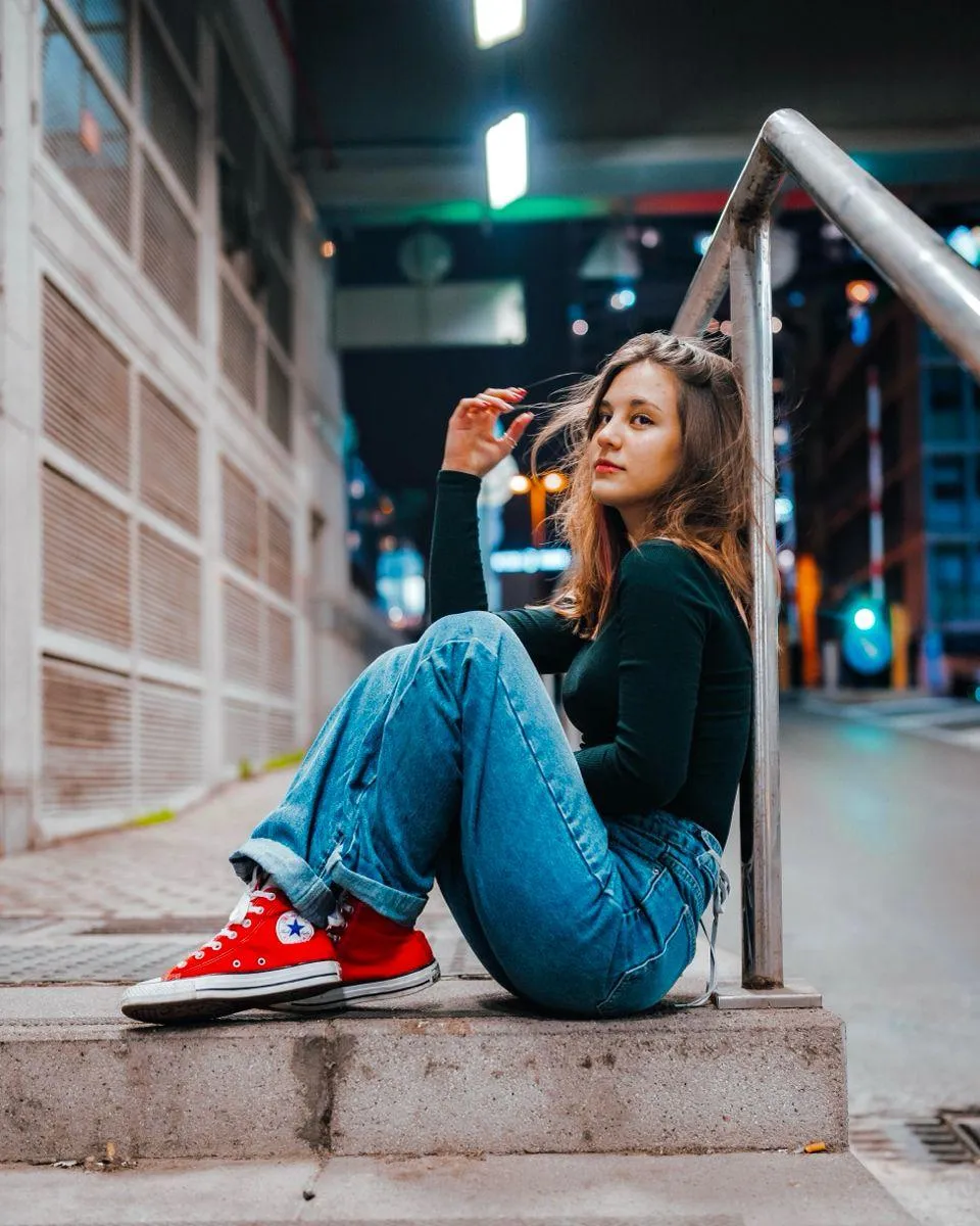 Girl in a Red Sneakers Sitting Casually on Nighttime Steps