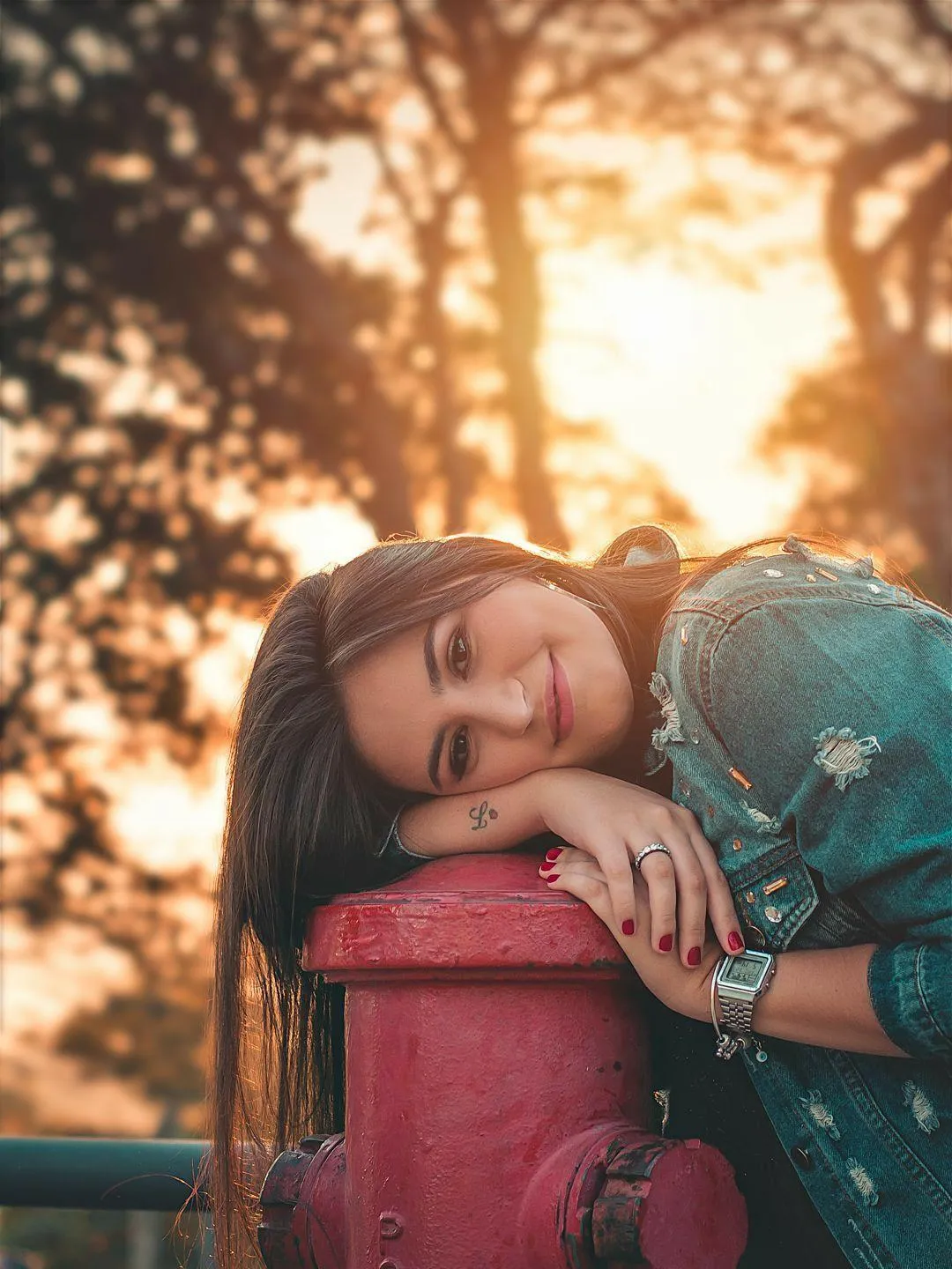 Girl Resting Her Head on a Red Pole Under Soft Sunset Light