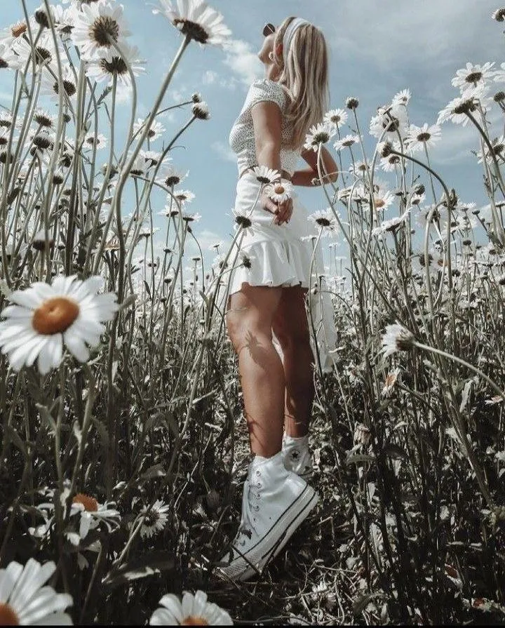 Girl Standing in a Daisy Field Wearing a White Casual Outfit