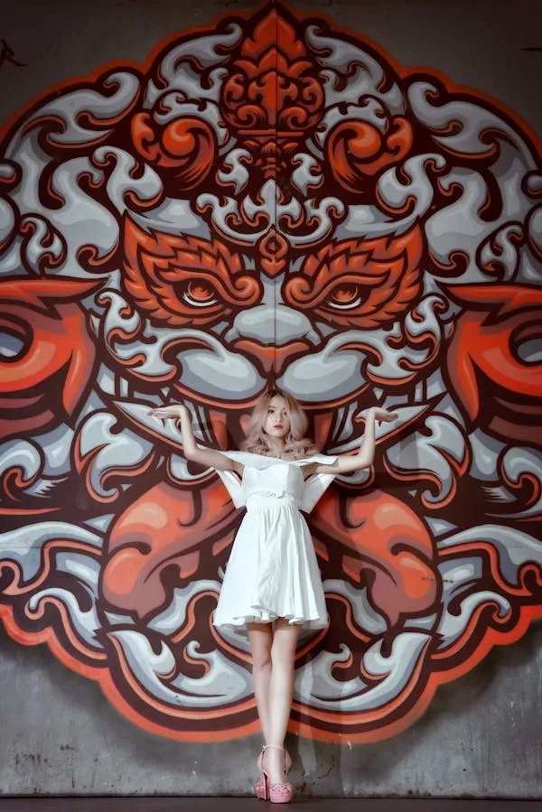 Girl in a White Dress Posing Near the Vibrant Artistic Mural