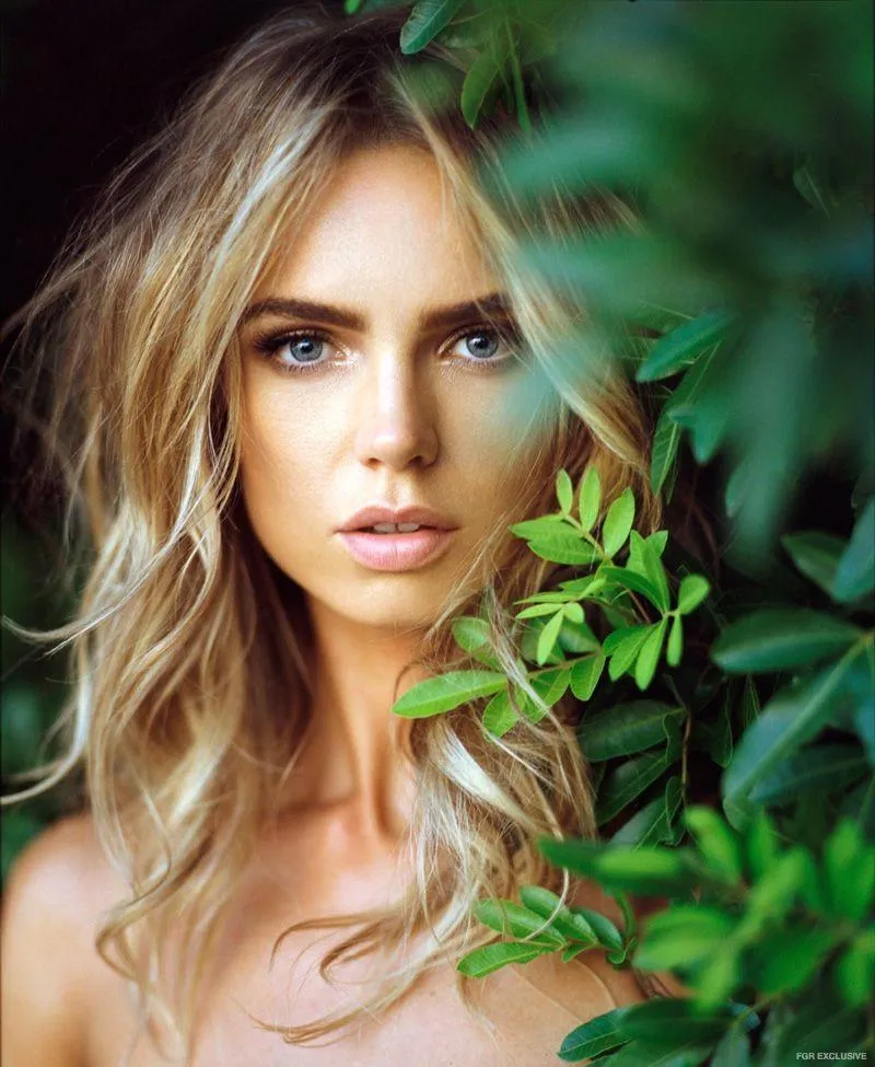 Glamorous Portrait of a Blonde Woman with Green Leaves Image