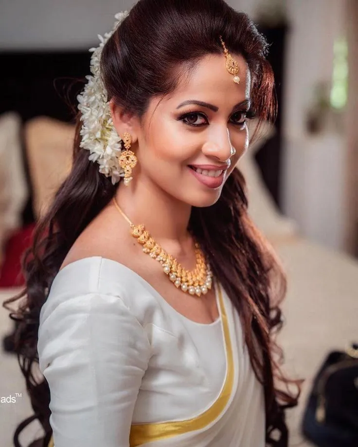 Glamour woman in an Onam saree with jasmine flowers image