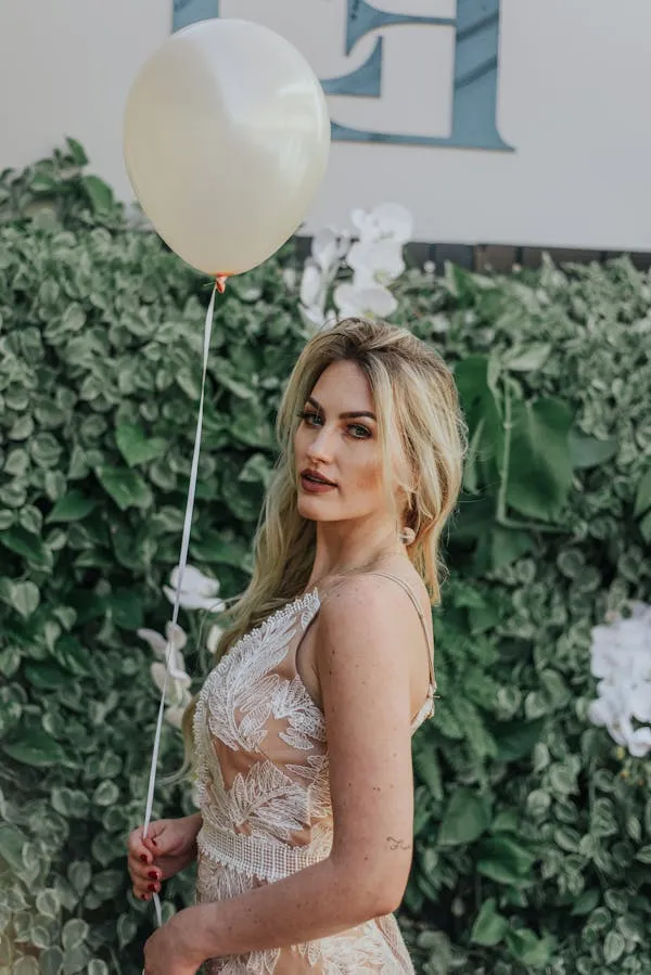 Gorgeous Woman in a Lace Dress Holding a Balloon At an Event