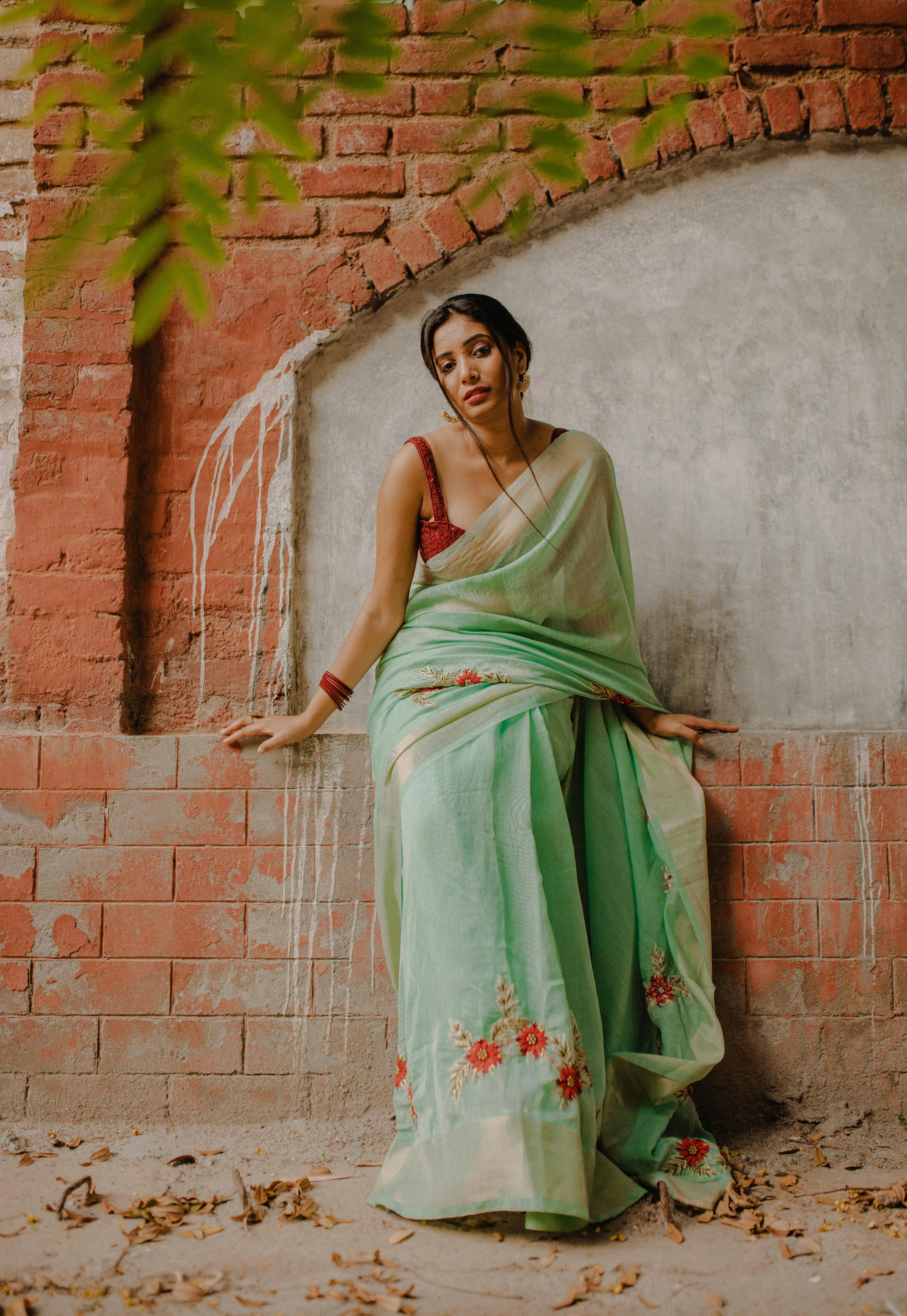 Gorgeous Young Woman in Green Saree Posing Near Brick Wall