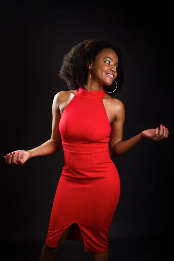 Happy Woman in Bold Red Dress Smiling in Black Background
