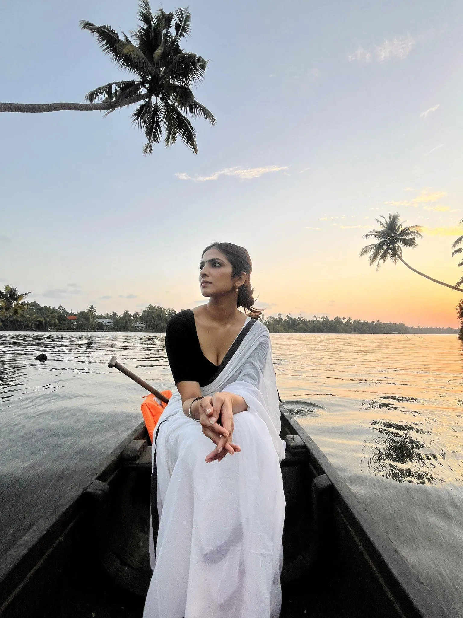 Hot Malavika Mohanan in White Saree Sitting on the Boat