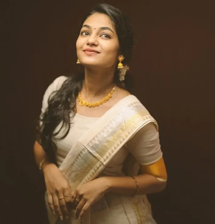 Ivana actress in an Onam saree looking sideways wallpaper