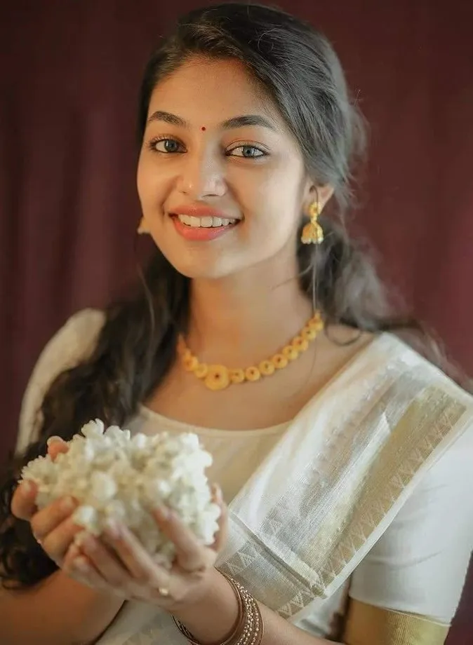Ivana in a white dress holding a jasmine flower in her hand