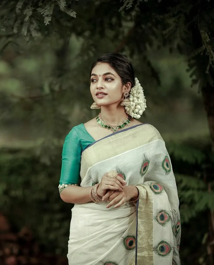 Ivana in a white saree with a green blouse looking sideways