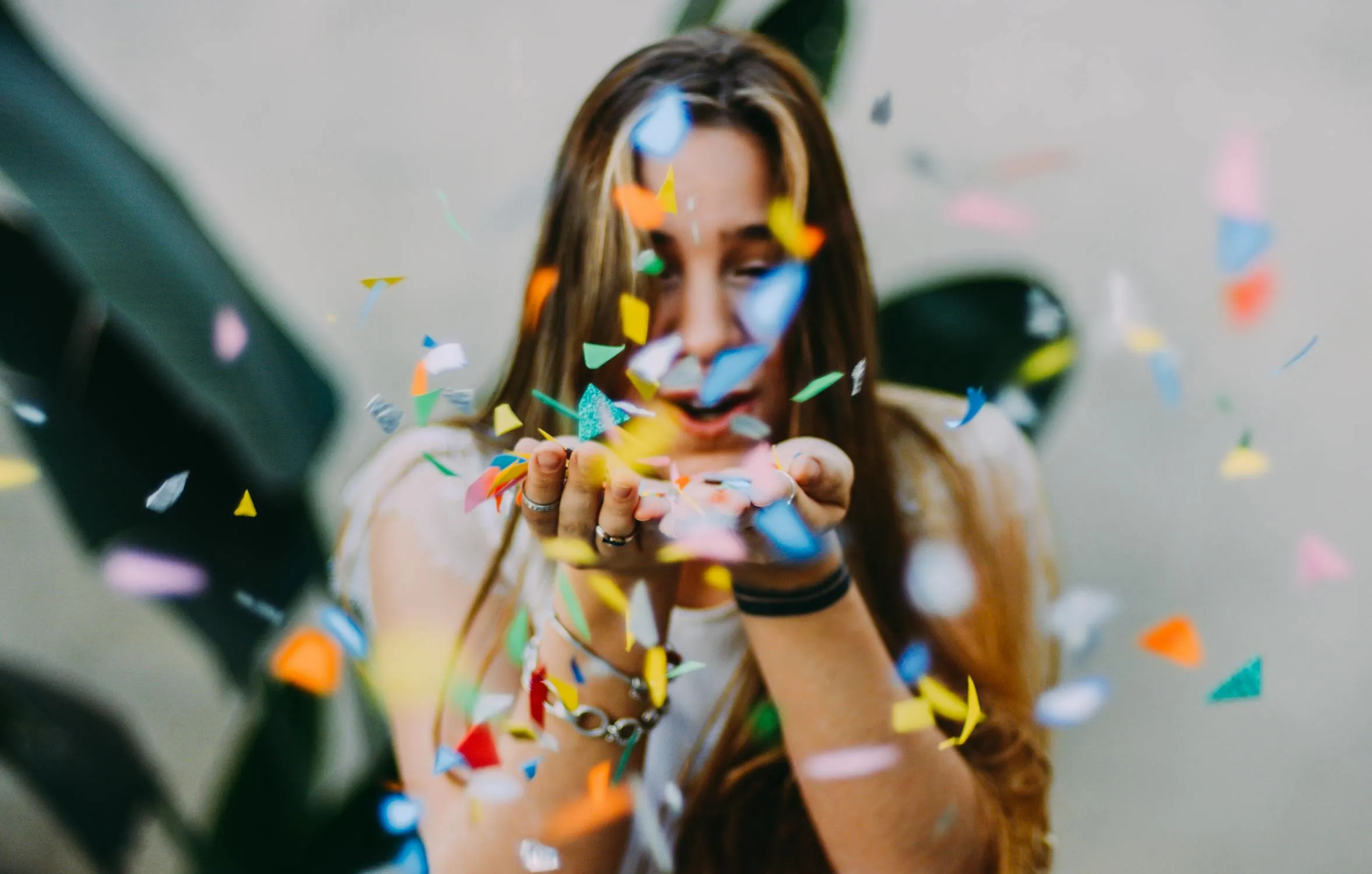Joyful Woman Blowing Confetti in Lively and Festive Setting