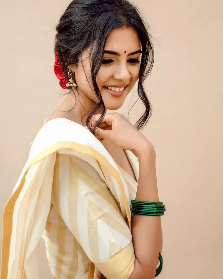 Kalyani Priyadarshan in a Neriyal saree standing near wall