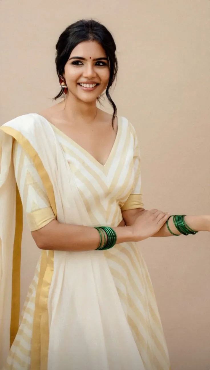 Kalyani Priyadarshan in an Onam dress standing near the wall