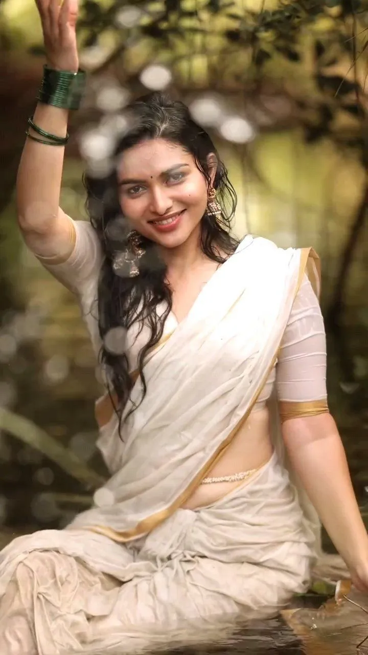 Kayadu Lohar in a wet Onam saree sitting in the water image