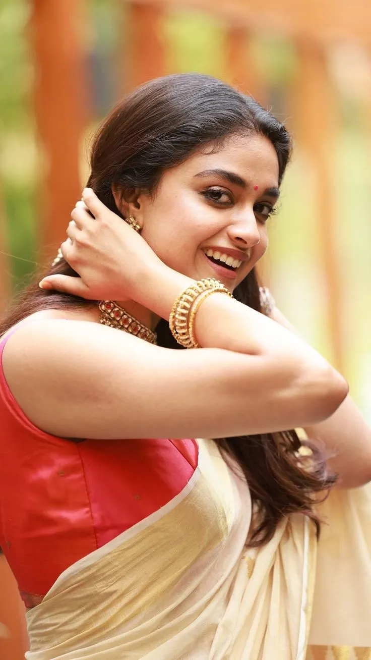 Keerthy Suresh in a Kerala saree with her hand on her hair