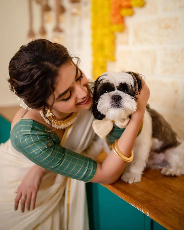 Keerthy Suresh in a saree playing with her dog Nyke image