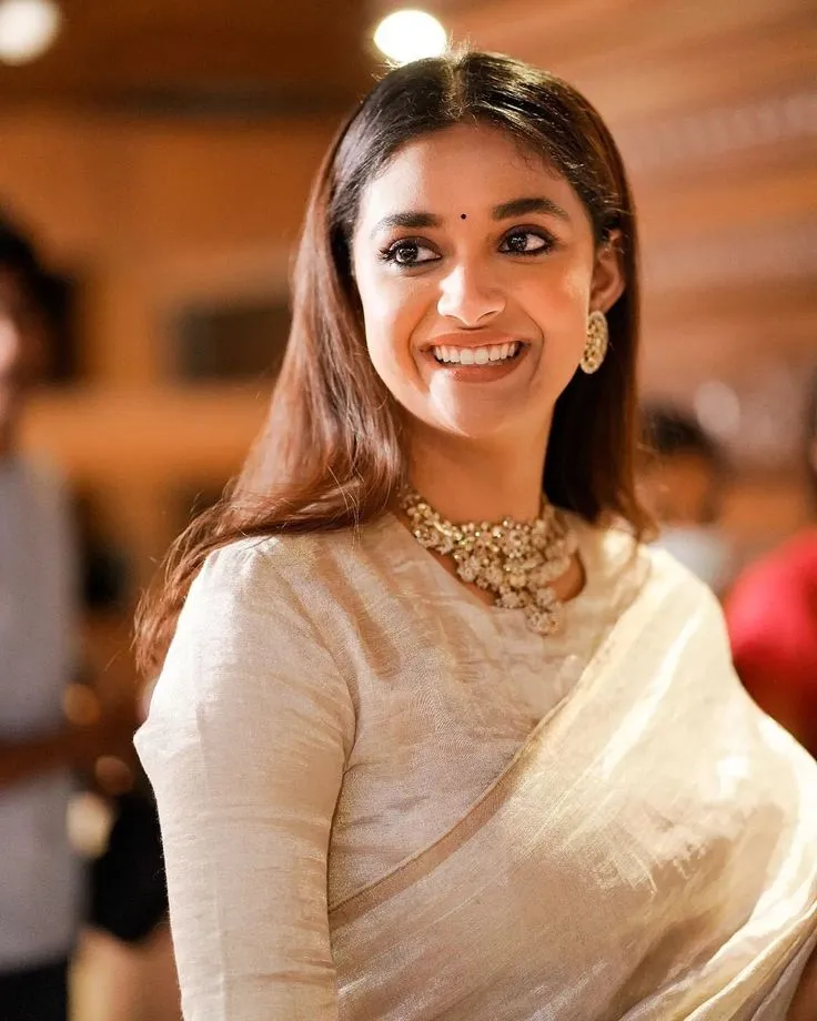 Keerthy Suresh in a white saree with a cute smile wallpaper