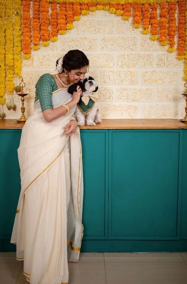 Keerthy Suresh with her dog Nyke wearing a white saree image