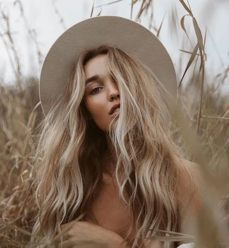 Long Haired Woman in a Hat Looking Dreamy in Soft Lighting