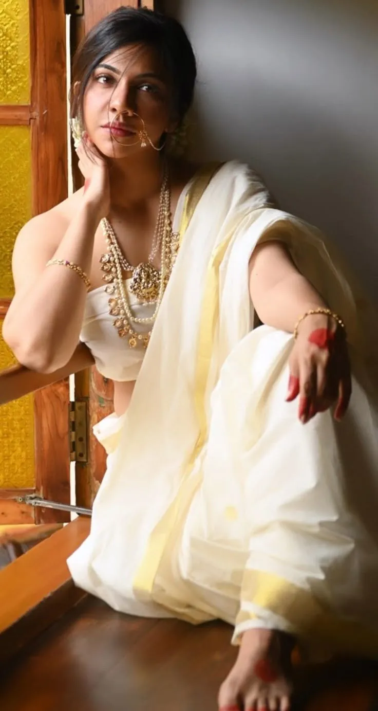 Madonna Sebastian in a hot pose sitting near the window