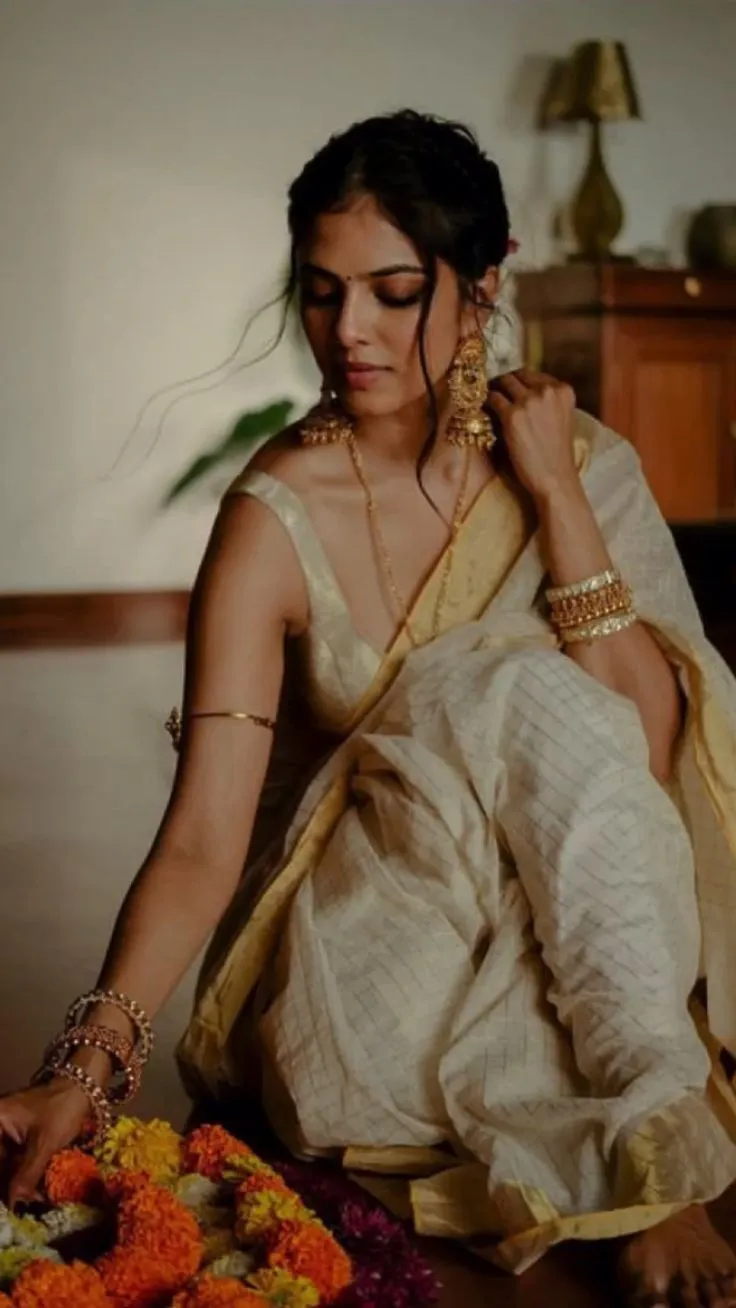 Malavika Mohanan in a checked white saree holding a flower