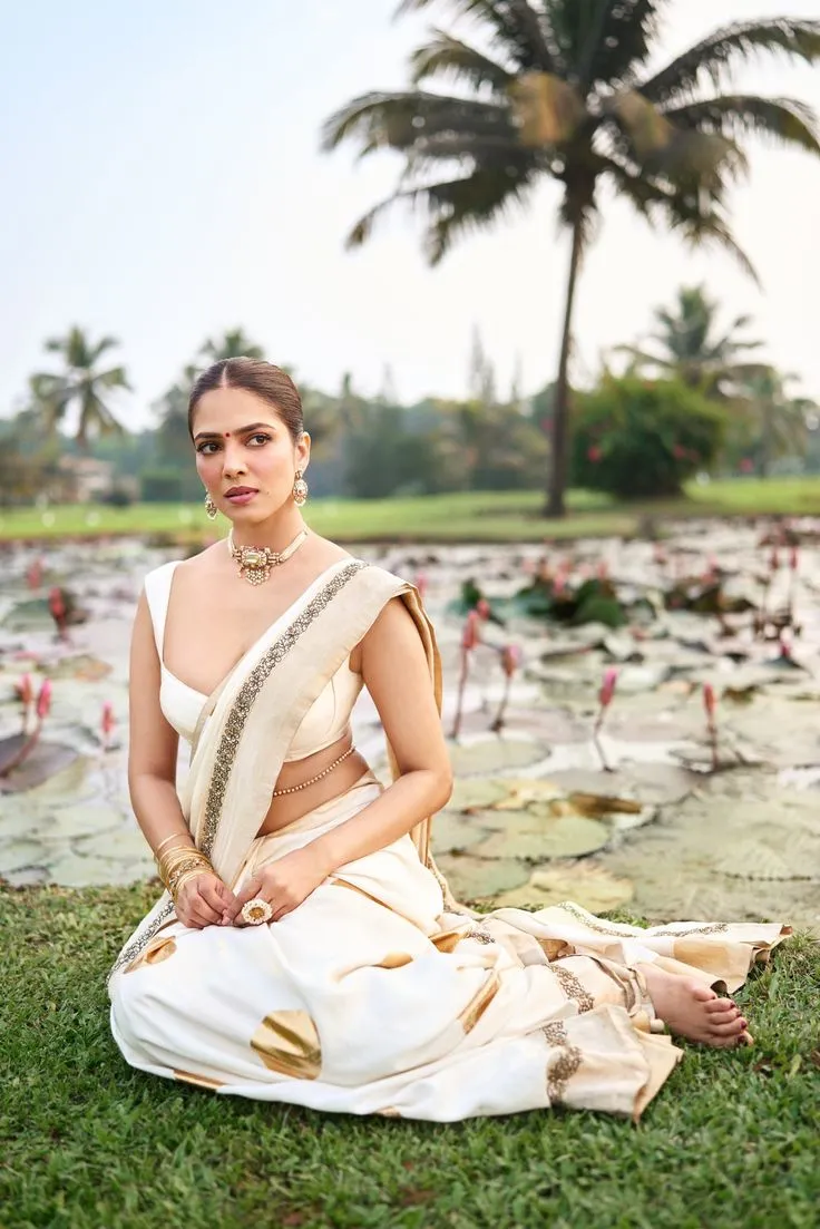 Malavika Mohanan sitting near the pond and looking intensely