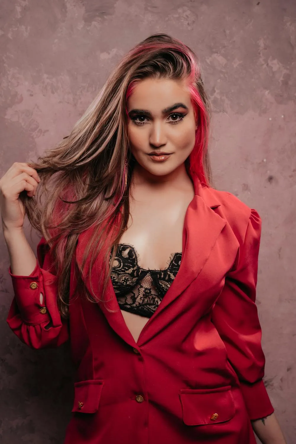 Model in a Red Outfit Posing with a Soft Pink Background