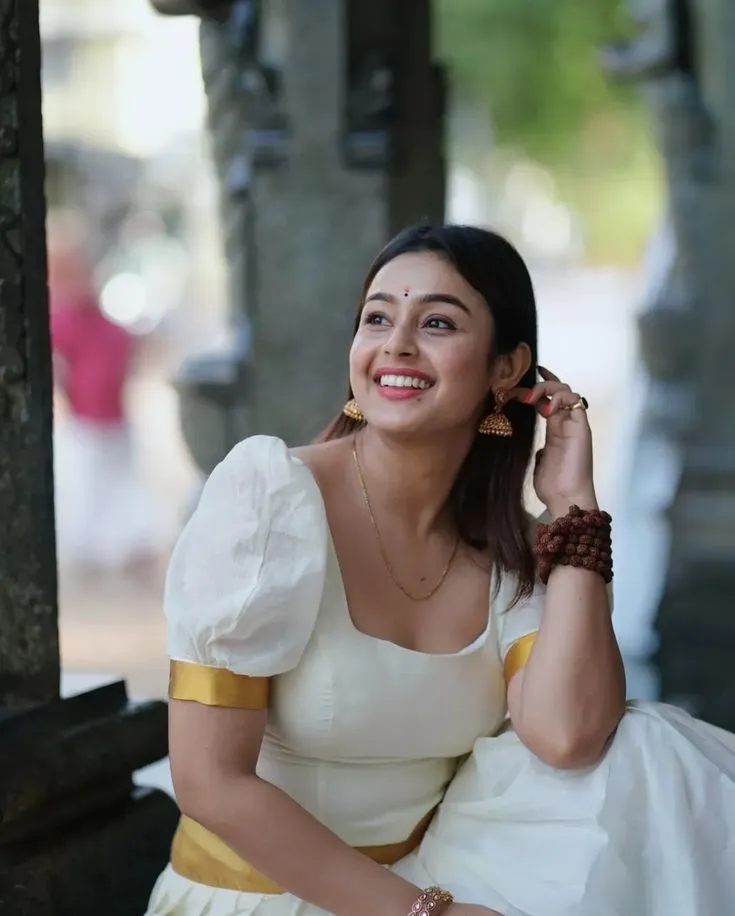 Mokksha in a traditional Kerala outfit sitting in a temple