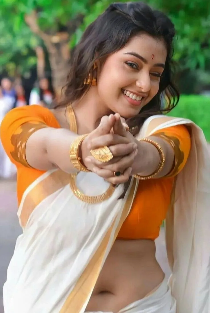 Mokksha in a white saree holding her hands together image