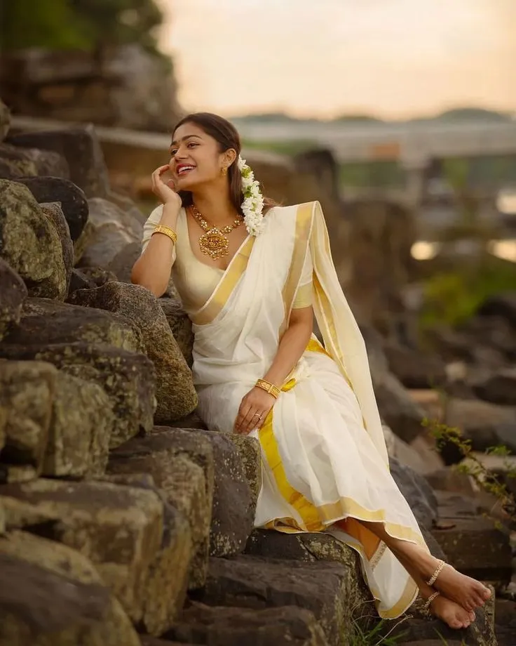 Payal Radhakrishna sitting rock wearing a traditional saree