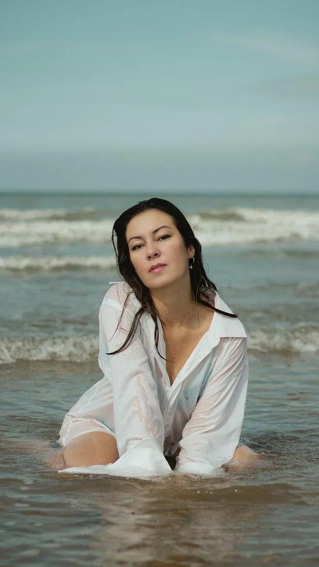 Peaceful Woman Sitting by the Sea Enjoying the Beach Breeze