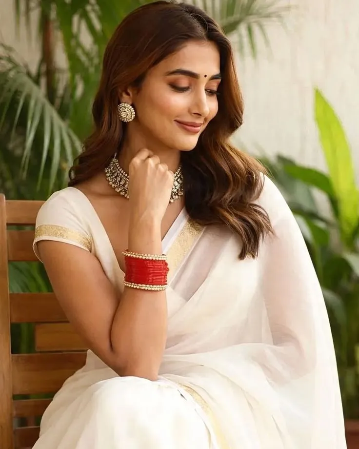 Pooja Hegde wearing a white saree with a looking down pose