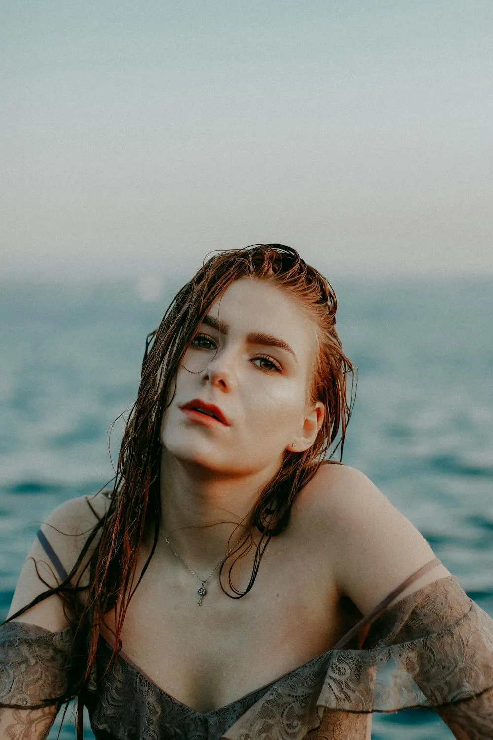Red Haired Woman Posing on the Beach with a Calm Expression
