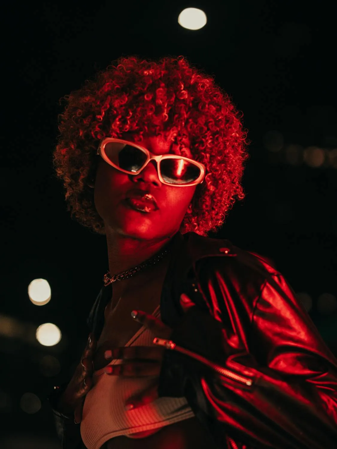 Red Light Glowing on a Confident Woman with a Curly Hair