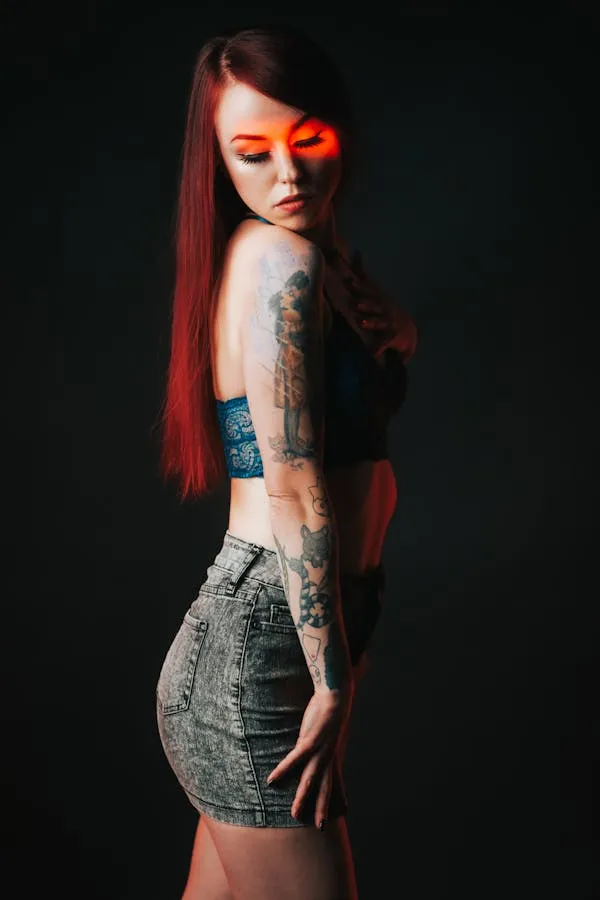 Redhead Model with Tattoos Posing in a Dark Studio Wallpaper