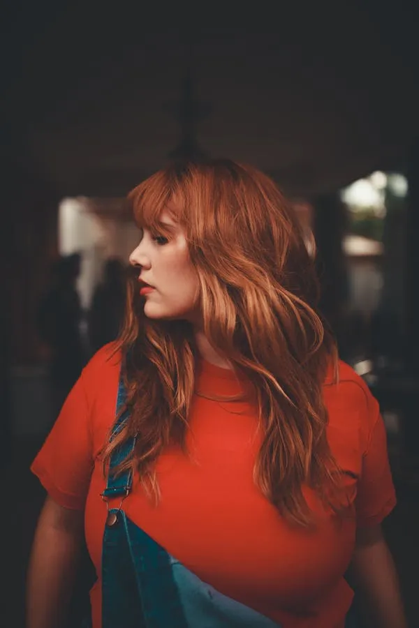Redhead Woman Wearing Red Shirt Looking Sideways Indoors